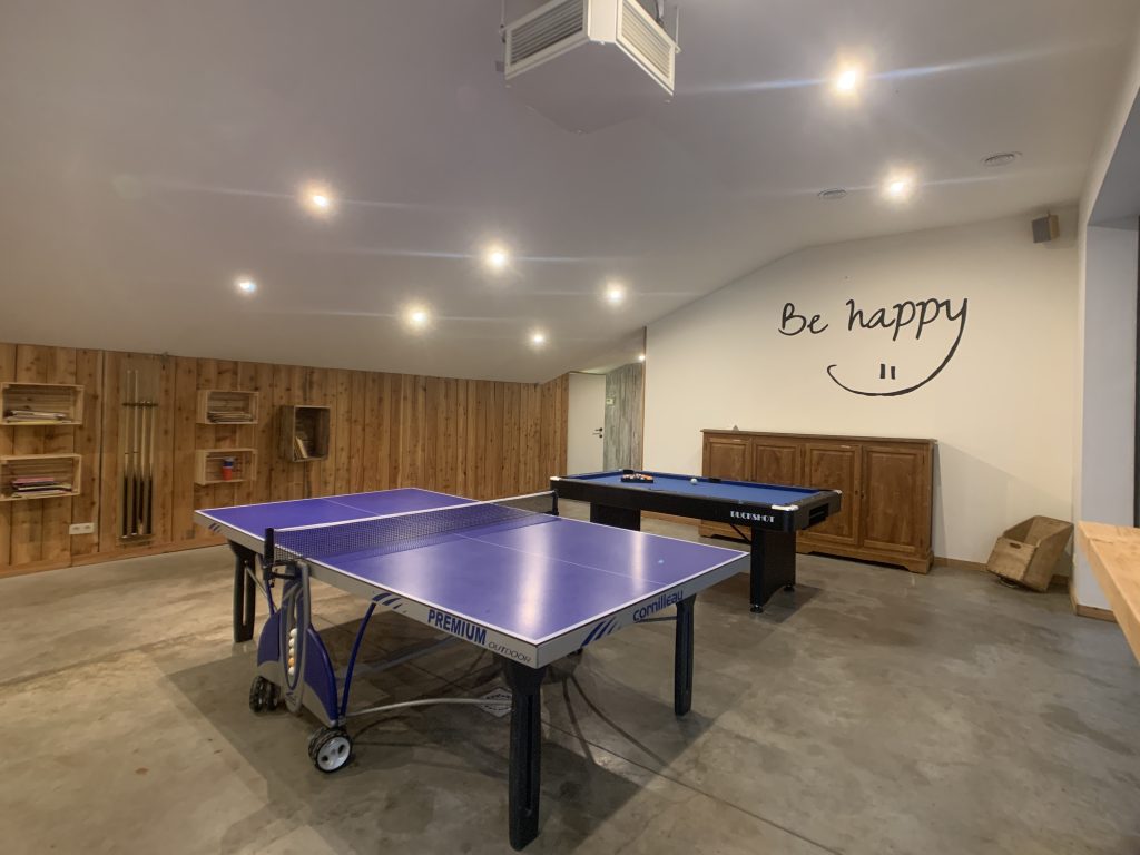 Salle de loisirs avec ping-pong, baby-foot et billard. A l'extérieur, il y a des karts et un trampoline pour les enfants.